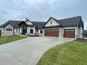 A two-story house with a stone facade, a driveway, and a well-maintained lawn. - MIZ-ZOU football weekend home
Awesome  house on Hole #7 at Old Hawthorne (Columbia)