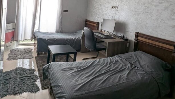 Un dormitorio con dos camas, un escritorio y una silla.