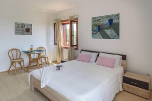 Ein Schlafzimmer mit einem Bett, einem Nachttisch und einem Schreibtisch mit Stühlen.