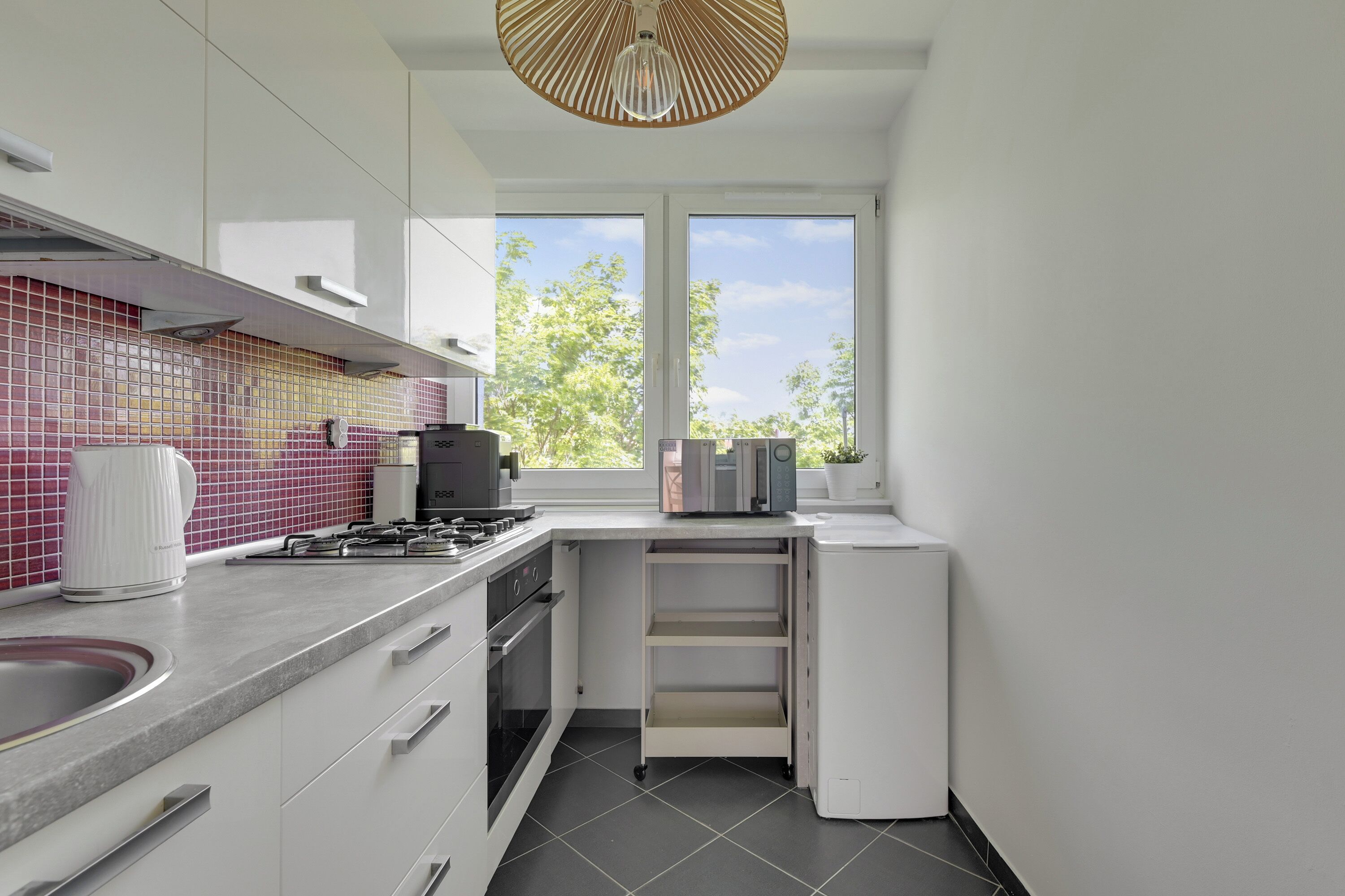 Una cocina moderna con estufa a gas, cafetera y microondas.