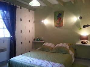 A bedroom with a bed, a nightstand, a wall clock, and a window with curtains. - 3-bedroom vacation rental, 10 minutes from Jonzac, fully fenced (Rouffignac)