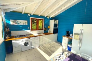A compact kitchen with a washing machine, a stove, and a refrigerator.