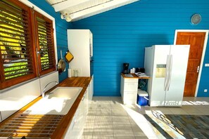 Eine Küche mit Spüle, Holzausziehtisch und Kühlschrank.