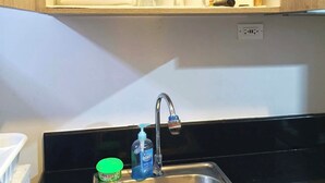 Eine Küche mit Spüle aus Edelstahl, einem Wasserhahn und einer Arbeitsplatte.