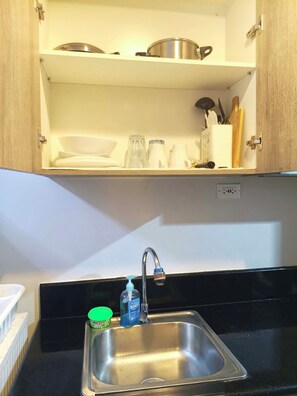 Eine Küche mit Spüle aus Edelstahl, einem Wasserhahn und einer Arbeitsplatte.