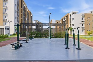 An outdoor gym area with exercise equipment, surrounded by apartment buildings. - Cozy 1-bedroom Apt in Punta Cana with Private Terrace (Punta Cana)