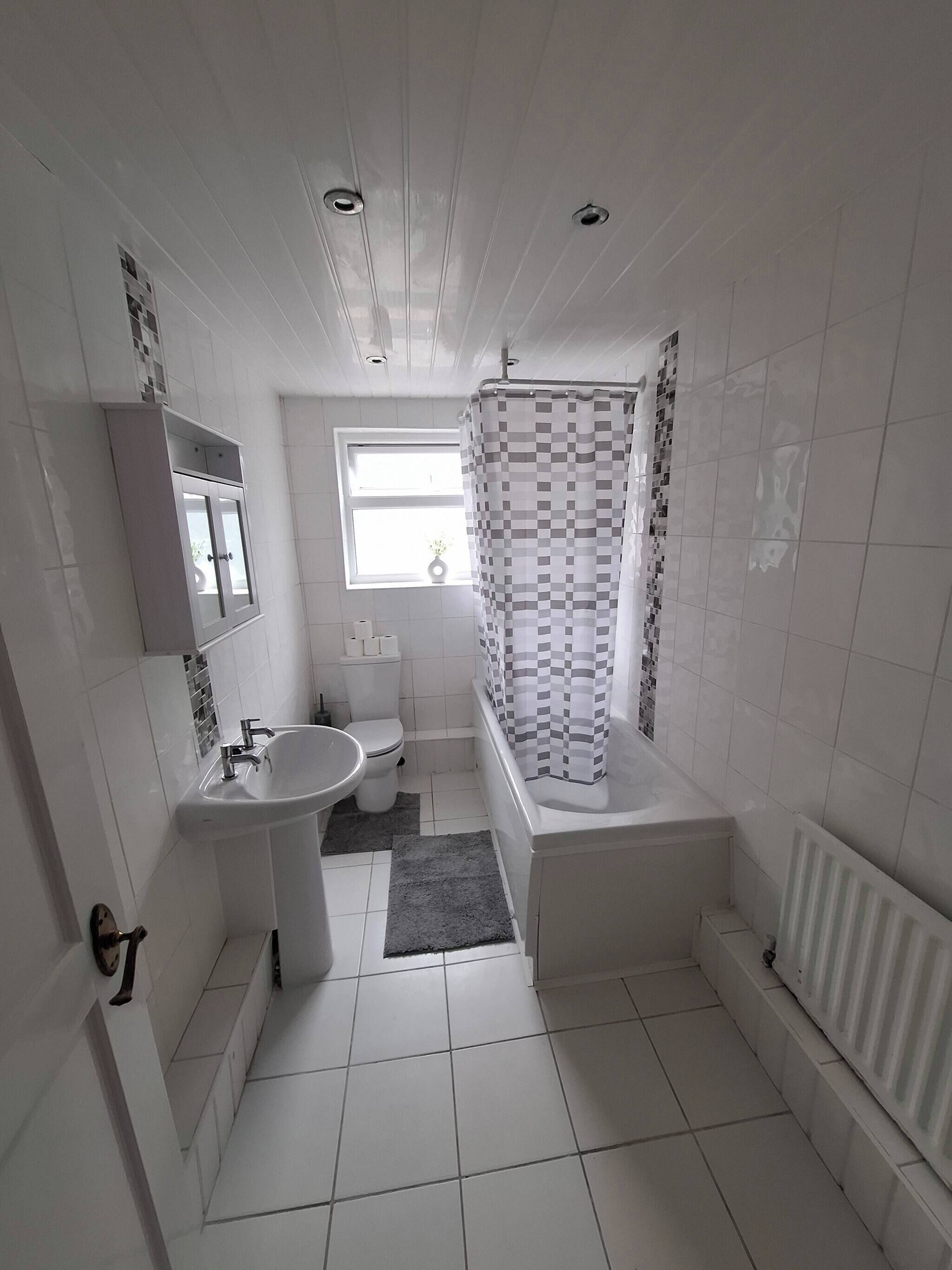 A bathroom with a toilet, sink, and bathtub.