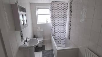 A bathroom with a toilet, sink, and bathtub.