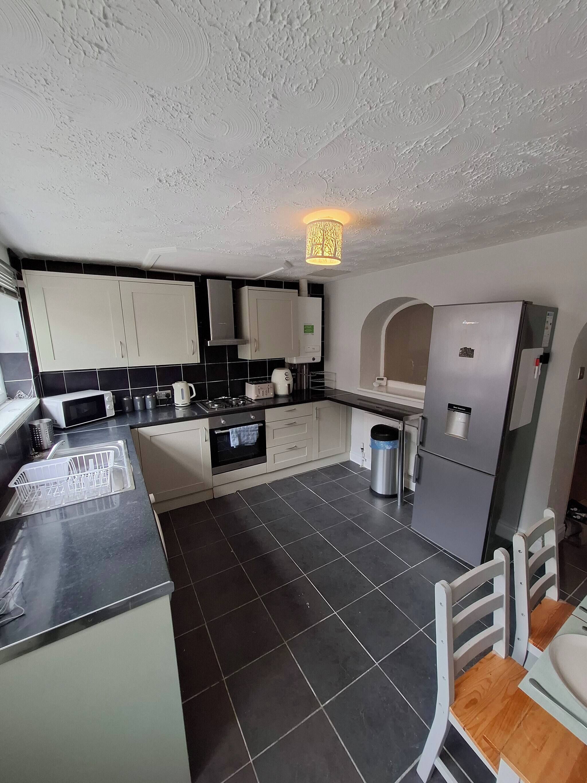 A modern kitchen with a microwave, stove, and refrigerator.