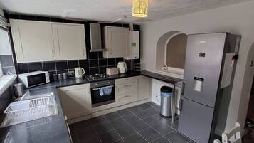 A modern kitchen with a microwave, stove, and refrigerator.