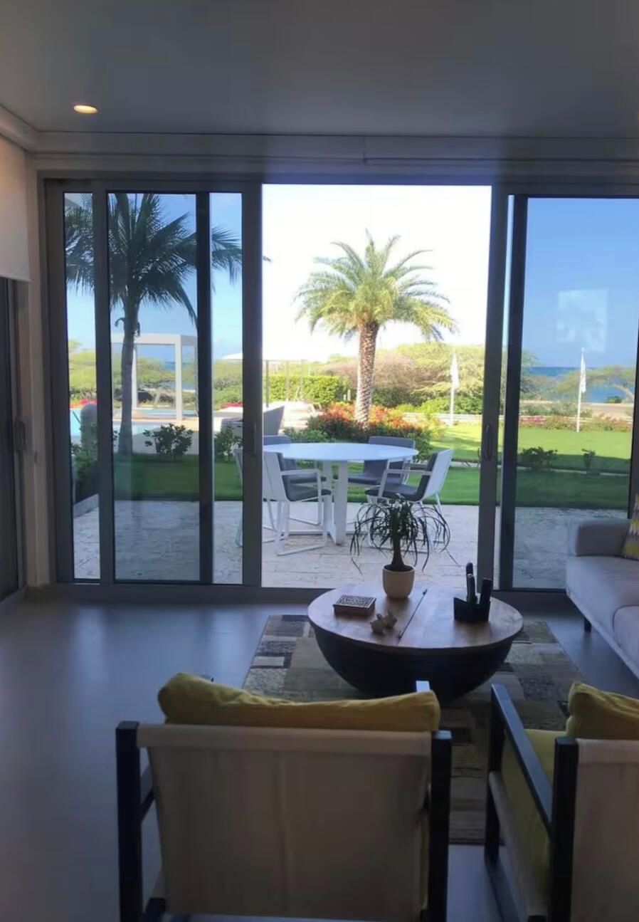 A modern living room with a large sliding glass door leading to an outdoor patio area.