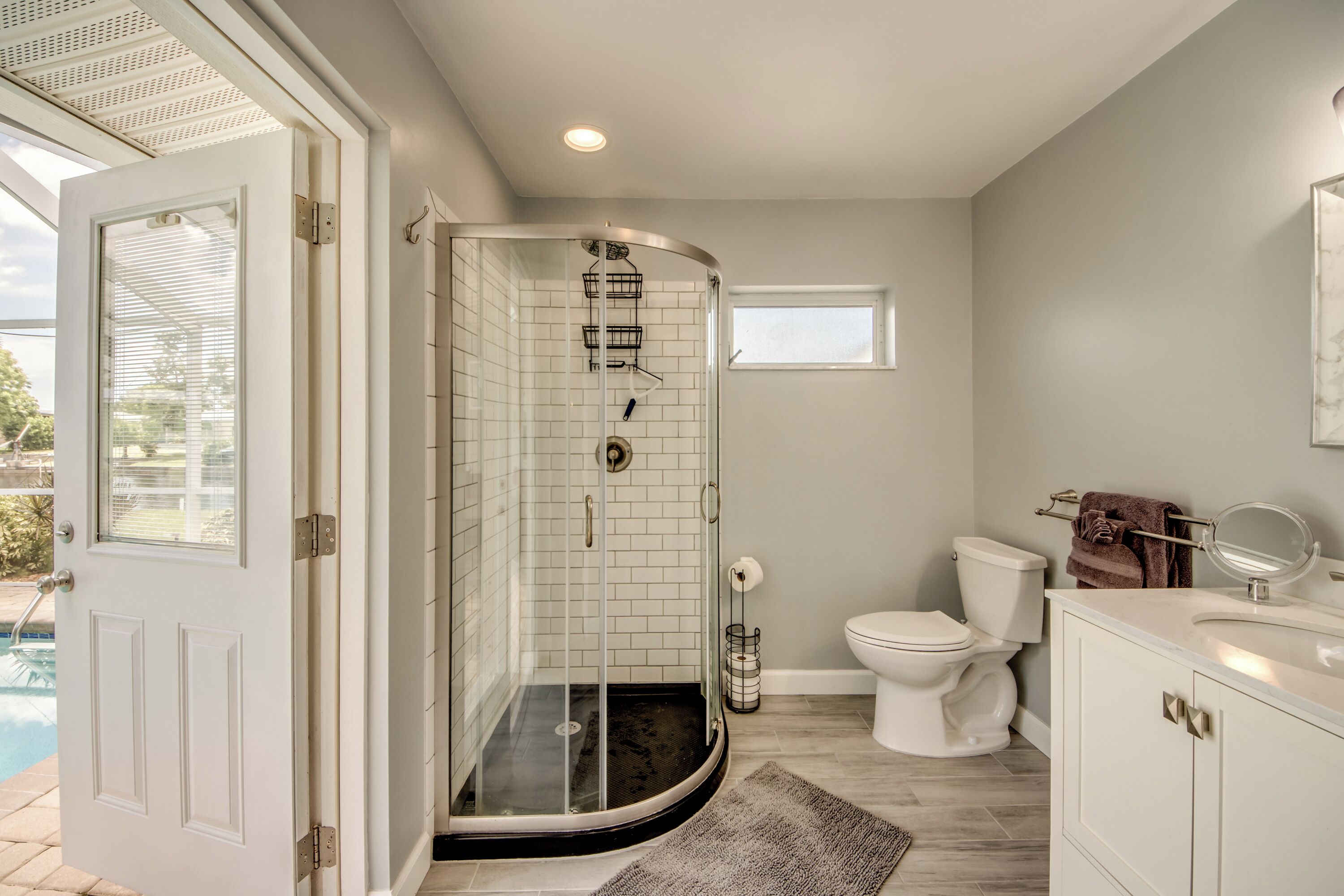Un bagno moderno con doccia vetrata, un WC e un lavandino.