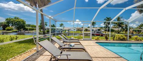 Zona junto a la piscina con sillones de descanso y una piscina.