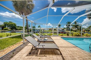 Uma área à beira da piscina com espreguiçadeiras e piscina.