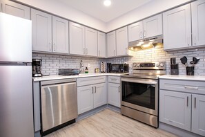 A modern kitchen with stainless steel appliances, white cabinetry, and a tiled backsplash. - Stylish 2Bed 2 Bath, Laundry, Gated Backyard, Smart Lock, Unit 2 (East Orange)