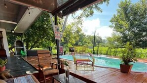Un área de estar al aire libre con cubierta de madera, un sofá y una mesa.