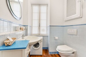 A bathroom with a sink, washing machine, toilet, and a window. - [La Loggia del Delfino] - 5 Terre Sea View A/C (Lerici)