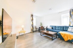 Ein modernes Wohnzimmer mit einer Couch, einem Couchtisch und einem Essbereich mit Stühlen und einem Tisch.