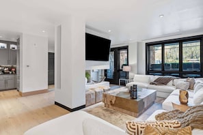 A modern living room with a white sofa, a coffee table, and a fireplace. - Solaris 4A East - 4 Bedroom + Den (Vail)
