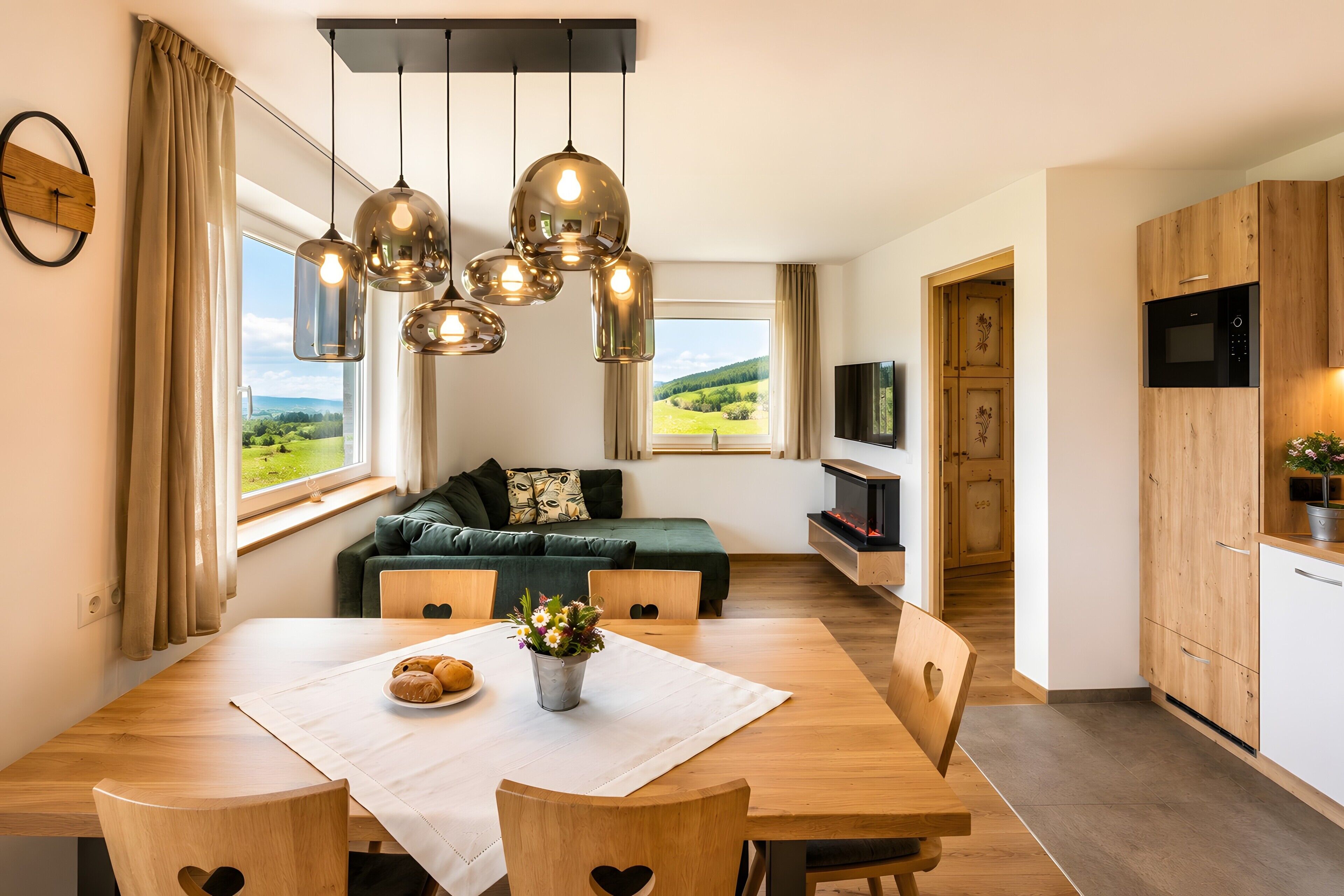 Una cucina moderna con mobili in legno, un forno integrato e un'area pranzo con un tavolo apparecchiato per due.
