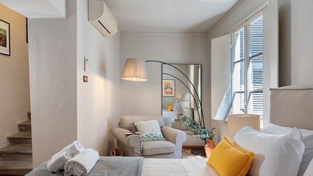 A modern bedroom with a bed, a chair, a desk, and a window. - 'Classy City-center Oasis' Apartment with Wi-Fi and Air Conditioning (Lucca)