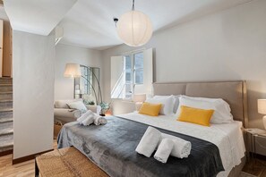 A hotel room with a bed, bedside tables, a lamp, a window, and a staircase. - 'Classy City-center Oasis' Apartment with Wi-Fi and Air Conditioning (Lucca)