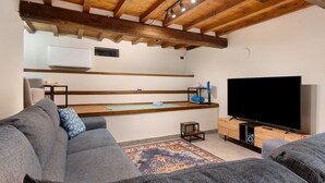 A modern living room with a wooden ceiling, a flat-screen TV, and grey sofas. - Apartment "Casa Conrad - Lucca" with Wi-Fi and Air Conditioning (Lucca)