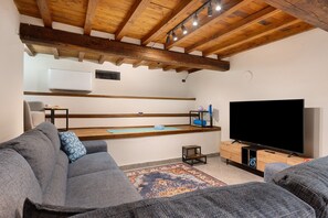 A modern living room with a wooden ceiling, a flat-screen TV, and grey sofas. - Apartment "Casa Conrad - Lucca" with Wi-Fi and Air Conditioning (Lucca)