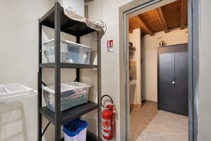 A storage area with shelves, a fire extinguisher, and a door leading to another room. - Apartment "Casa Conrad - Lucca" with Wi-Fi and Air Conditioning (Lucca)