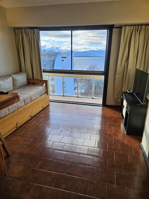 A room with a sofa, a TV, and a view of a body of water. - Lake and City steps from the Centro Civicoc (San Carlos de Bariloche)