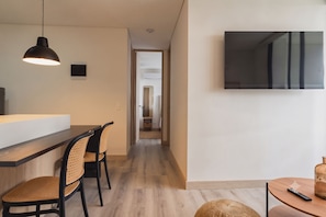A modern kitchen with a wooden countertop, two wicker chairs, and a pendant light. - ENZO Privé | Grand - Exclusive Corporate Suite in Medellín (Medellín)