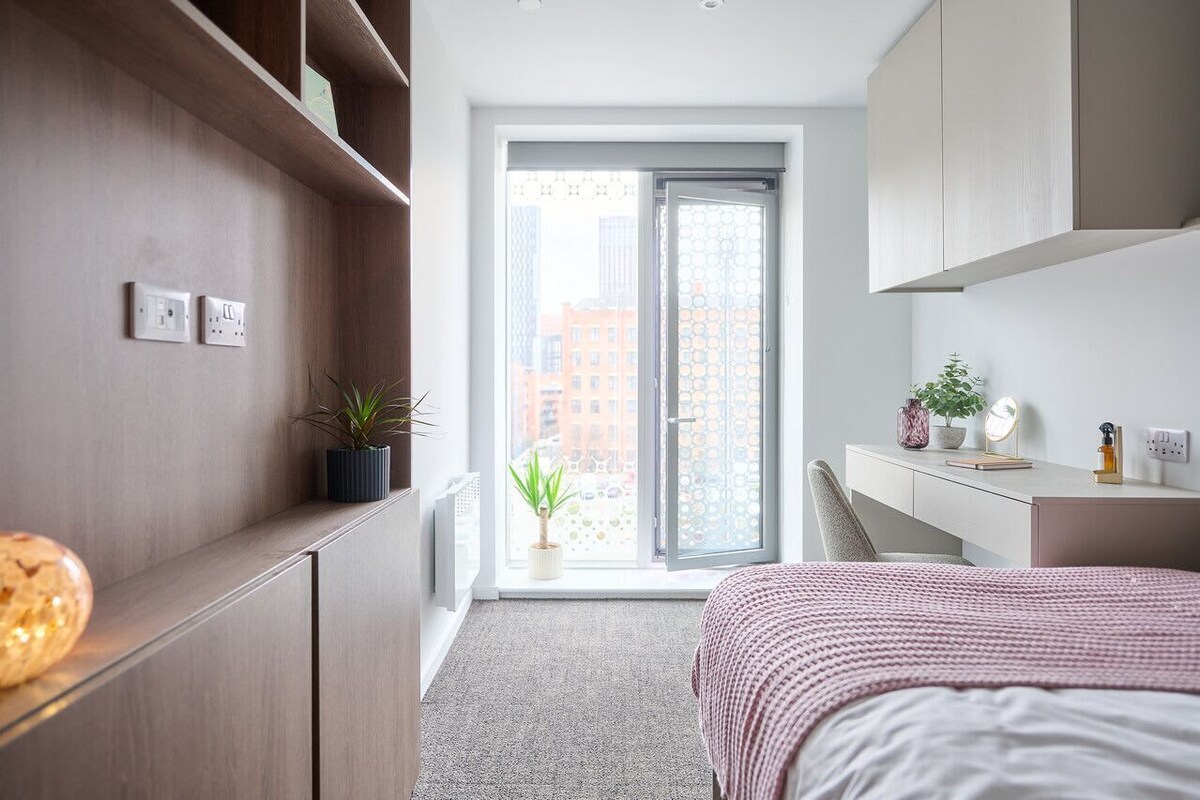 Ein modernes Schlafzimmer mit einem Bett, einem Schreibtisch und einem großen Fenster.