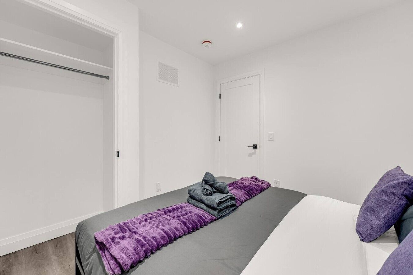 A bedroom with a bed, a wardrobe, and a door.