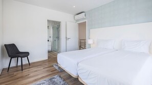 Ein Hotelzimmer mit Bett, Stuhl, Duschbereich und Kleiderschrank.
