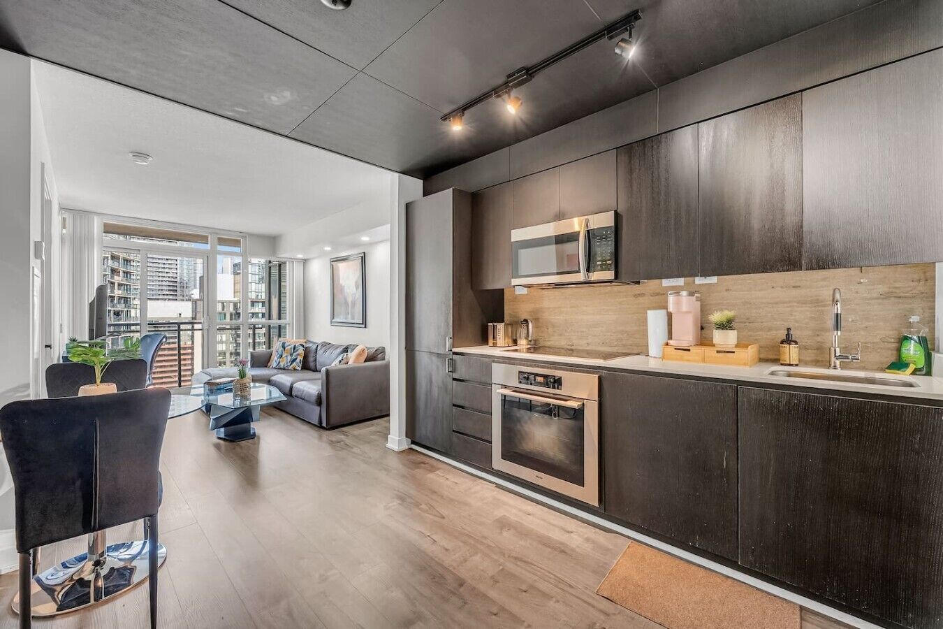 A modern kitchen with dark cabinetry, a microwave, and a built-in oven.
