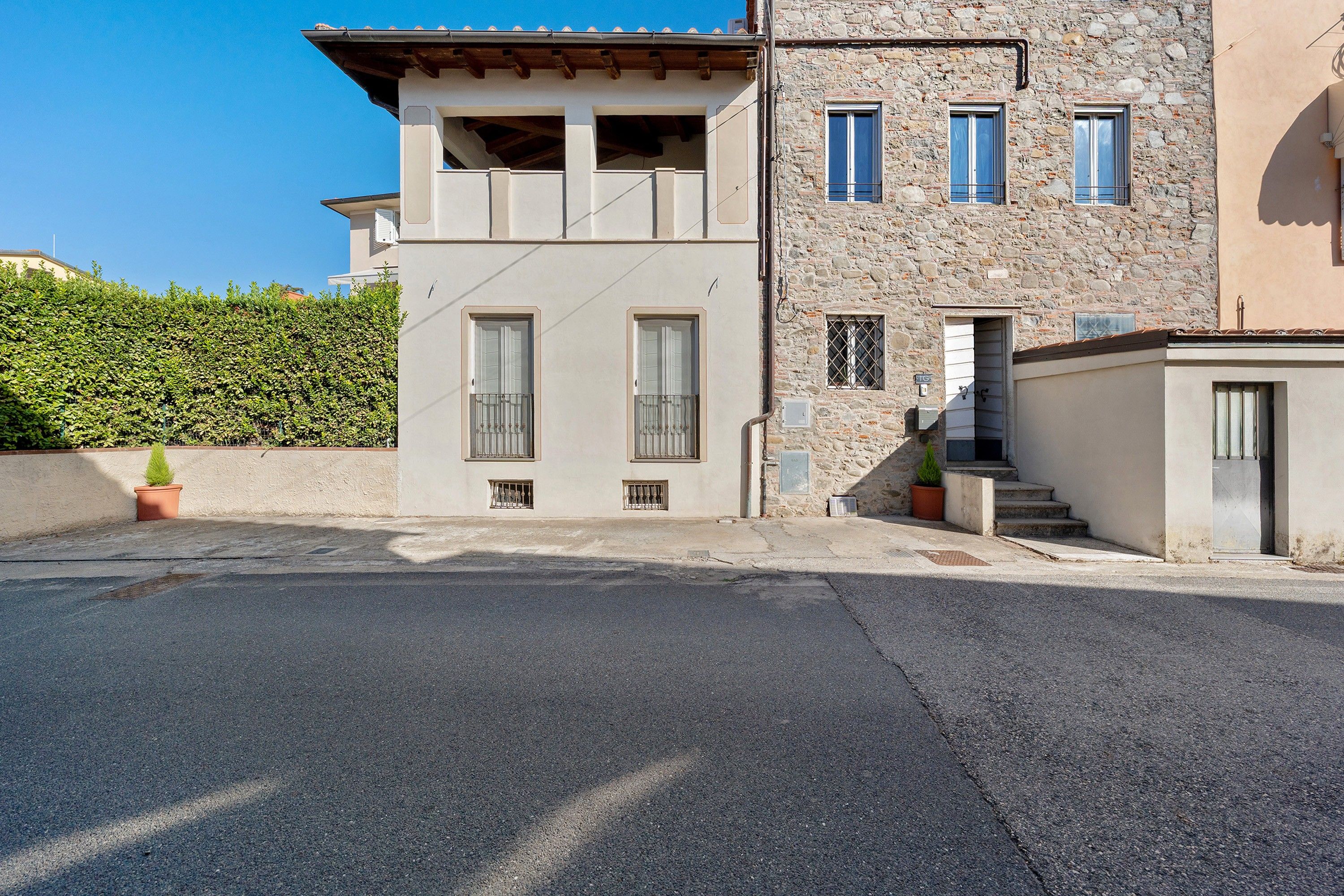 Un edificio de dos pisos con fachada de piedra y techo plano.