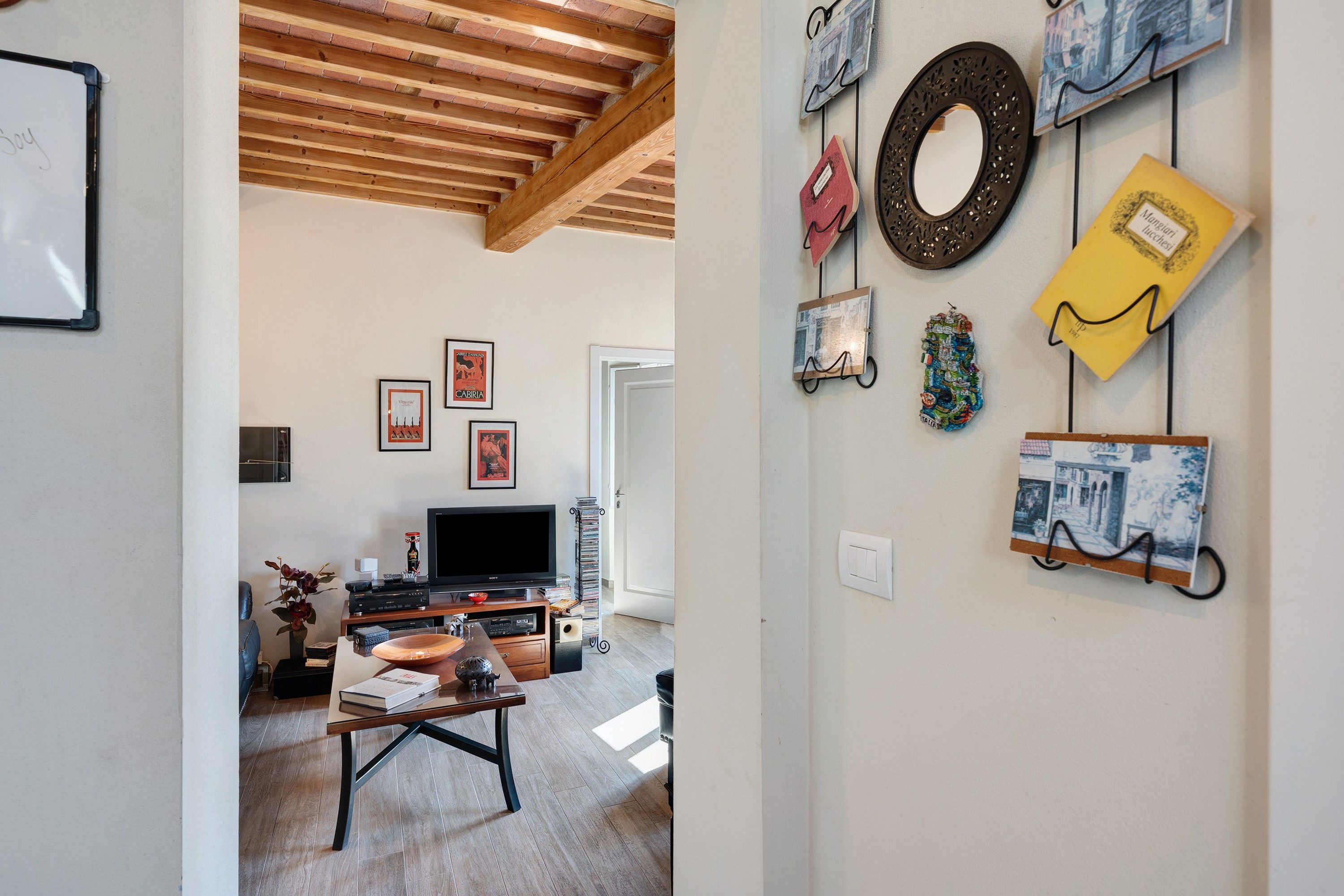 Una sala de estar con televisión, una mesa de centro y una estantería.