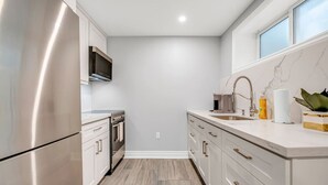 A modern kitchen with stainless steel appliances, a marble countertop, and a built-in oven. - *Minutes to BMO Field* 3BR Home in Downtown (Toronto)