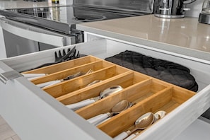 A kitchen drawer with multiple compartments for utensils.