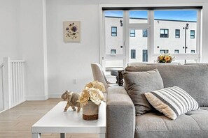A modern living room with a grey sofa, a white coffee table, and a decorative elephant figurine.