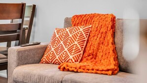 Una silla con una manta y una almohada.