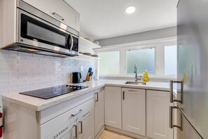 A modern kitchen with white cabinetry, a stainless steel refrigerator, a microwave, and a built-in oven. - *1 Minute to BMO Field* 4 Bedroom Home In Downtown (Toronto)