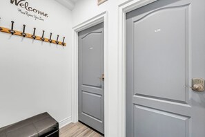 A hallway with a coat rack, a bench, and two doors, one labeled 'MAIN' and the other with a keypad lock. - *1 Minute to BMO Field* 4 Bedroom Home In Downtown (Toronto)