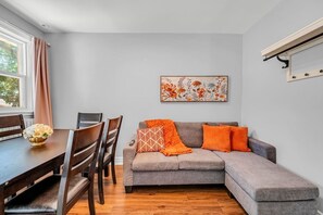 A modern living room with a dining table, sofa, and artwork on the wall. - *1 Minute to BMO Field* 4 Bedroom Home In Downtown (Toronto)