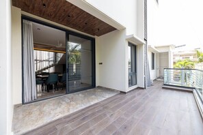Eine moderne Wohnung mit geräumigem Balkon, einer Schiebetür zu einem Essbereich und einer Holzbalkendecke.