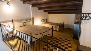 A bedroom with a bed, a bedside table, a wardrobe, and a checkered floor.