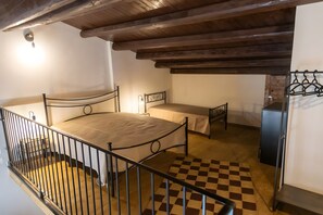 A bedroom with a bed, a bedside table, a wardrobe, and a checkered floor.