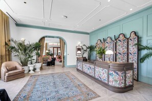 A hotel lobby with a reception desk, seating area, and a view into the room. - Wynwood Luxury Atelier Resort (Miami)