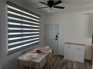 A dining area with a table set for four, a ceiling fan, and a white cabinet. - Gorgeous 3-bedroom apartment with AC and pool in vibrant Isabela (Isabela)