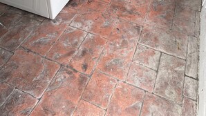 Un'area lavanderia con due lavatrici bianche e un pavimento piastrellato.